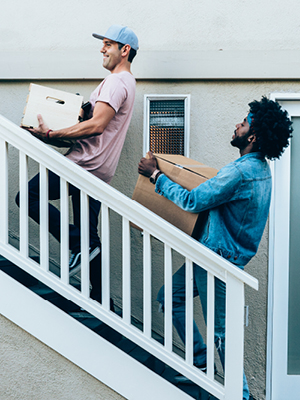 two people carrying boxes up the stairs