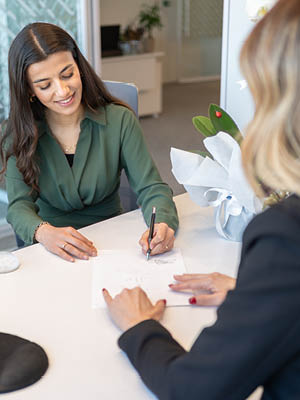 two women signing a piece of paper