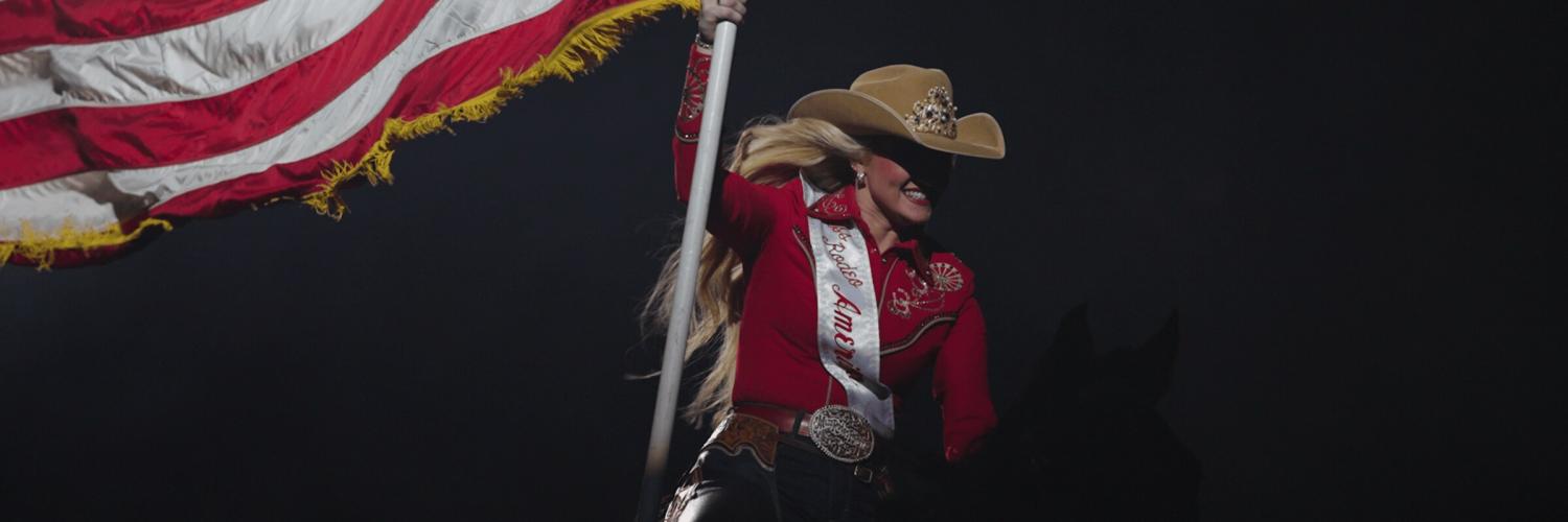 woman in cowboy had with a flag