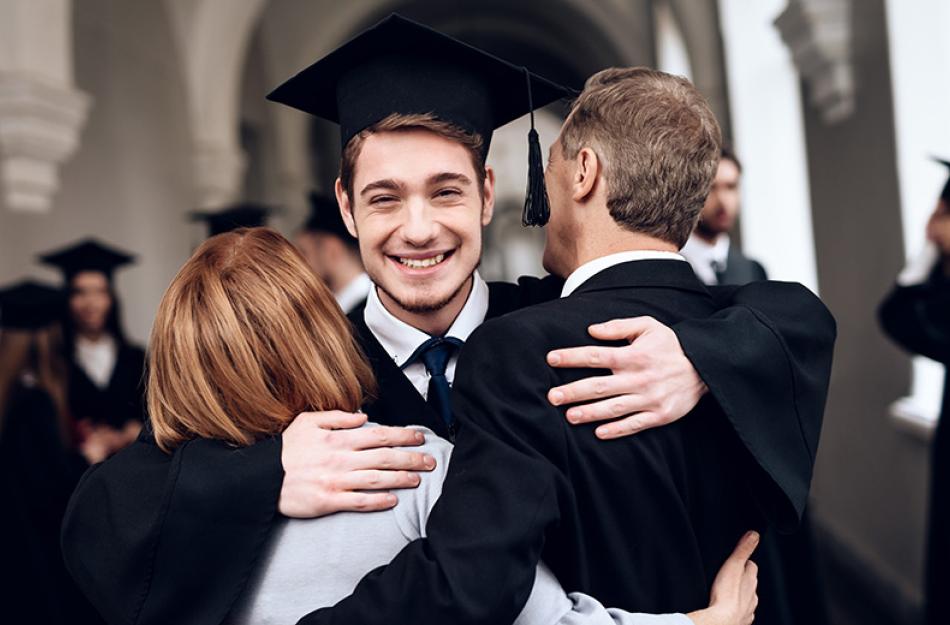 son hugging parents at graduation