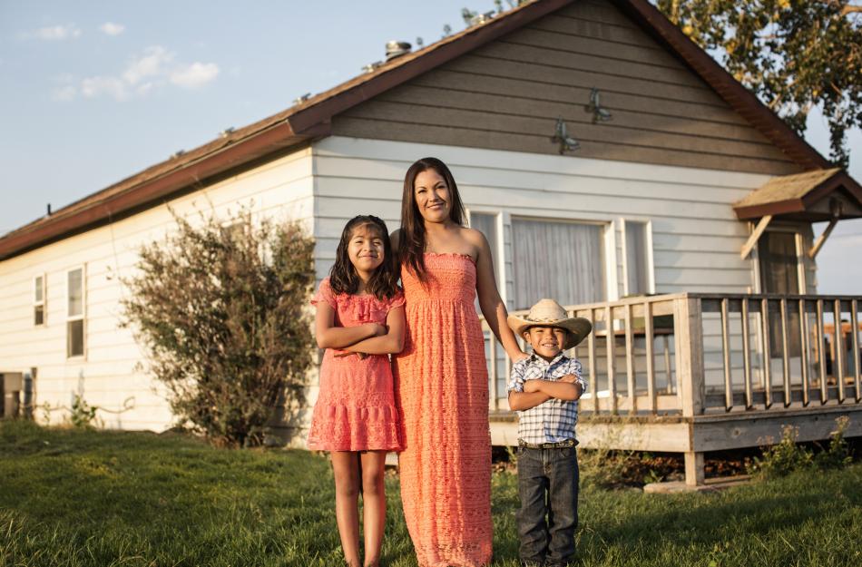 mom and kids standing in front of a home