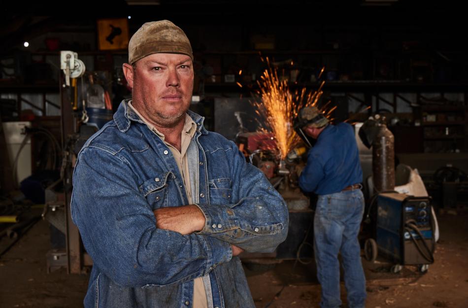 Man standing at a welding site.