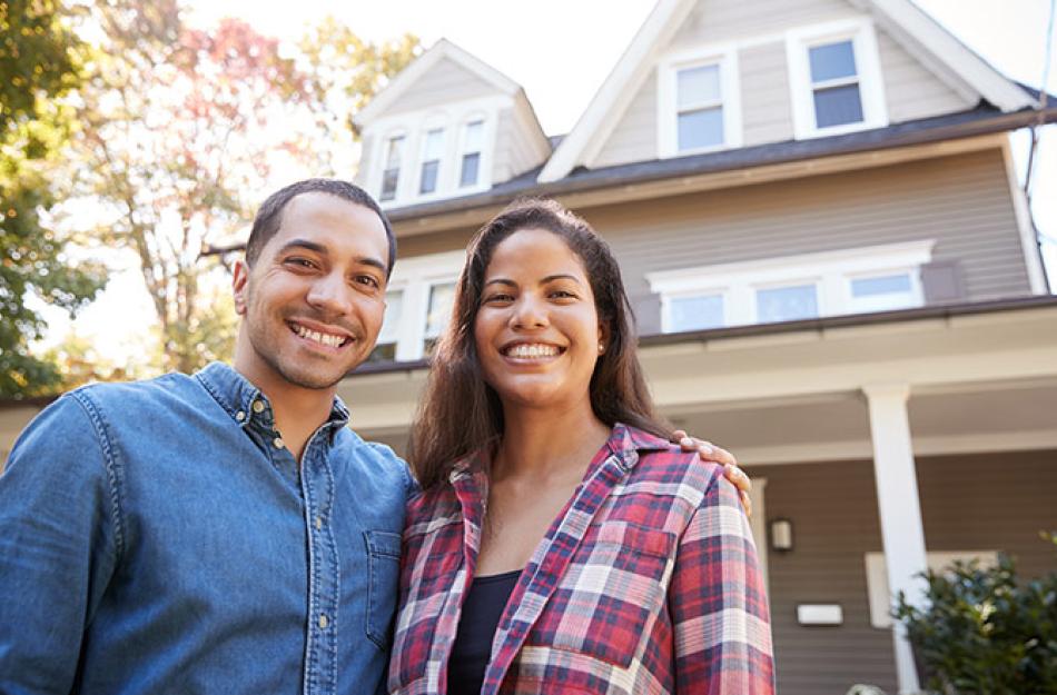 smiling couple in front of a house