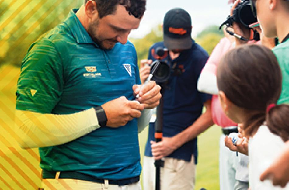 Golfer signing autograph for a child