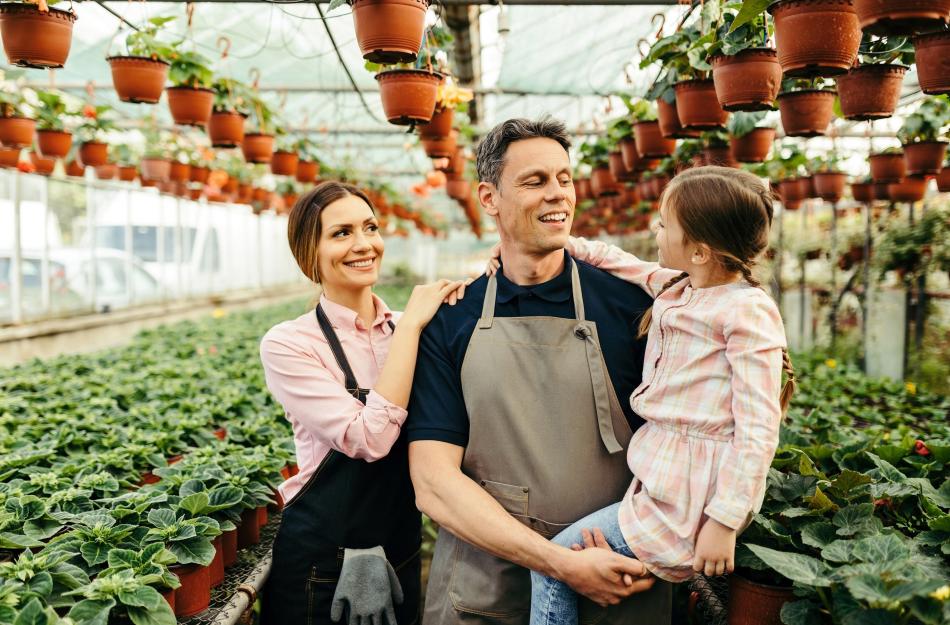 3 people walking around a greenhouse