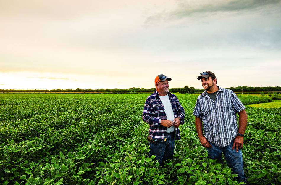 Farmers in their field smiling and talking