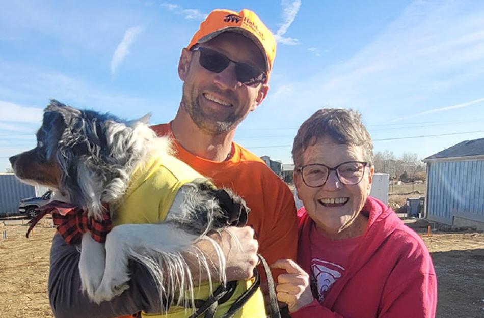 MAN AND WOMAN HOLDING A DOG
