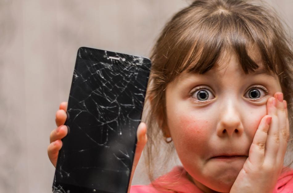 picture of a little girl holding a cracked cell phone