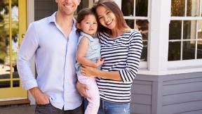 family in front of their new home