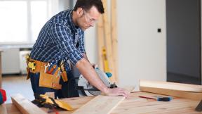 Man cutting wood with a saw.