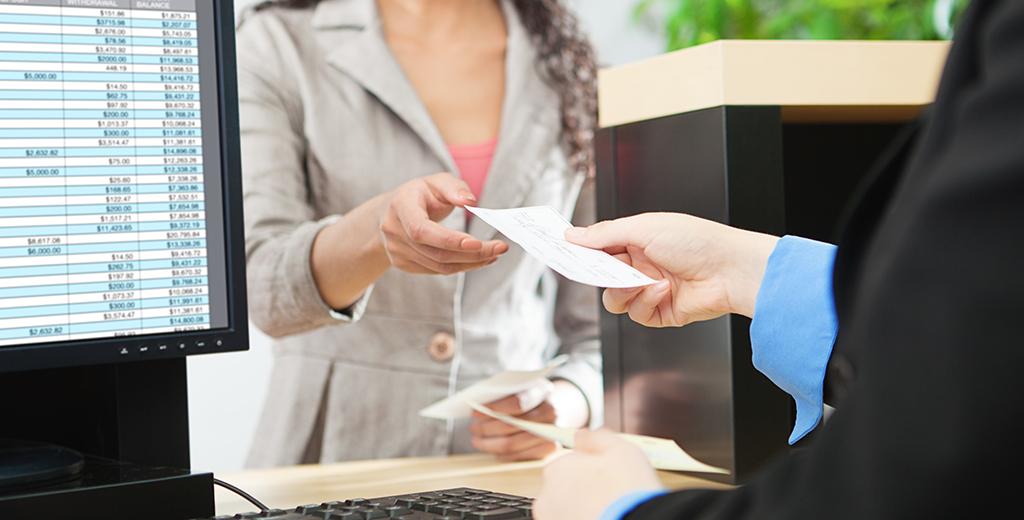 Customer giving a check to the bank teller.