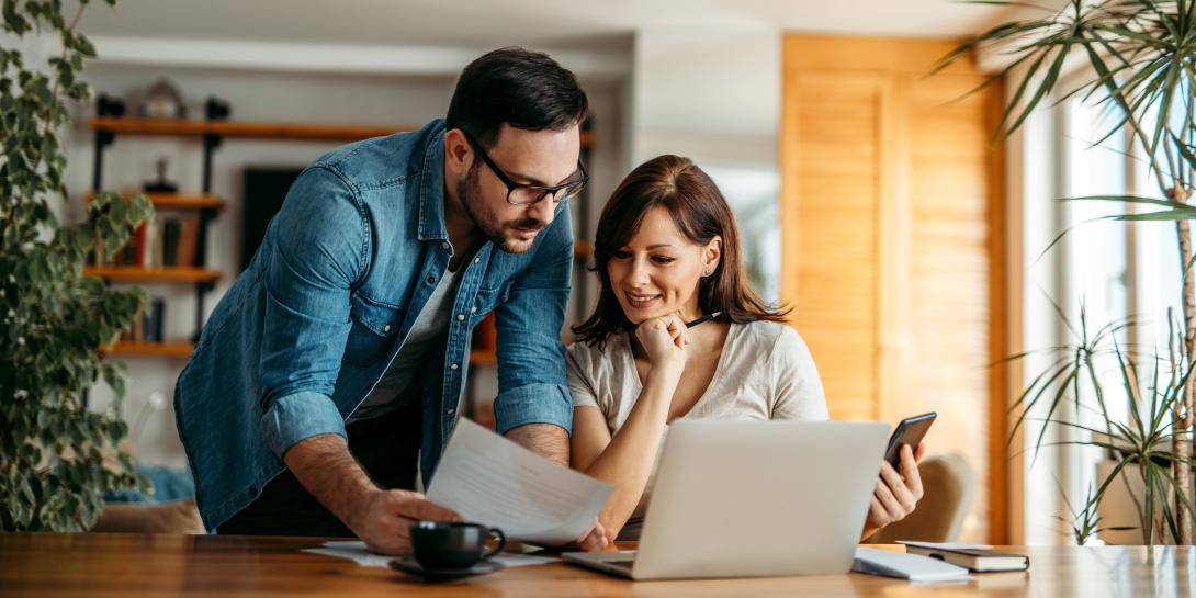 couple looking at a piece of paper while working