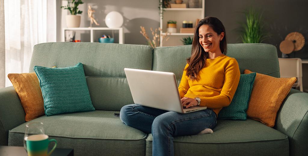 woman sitting on the sofa using her laptop computer