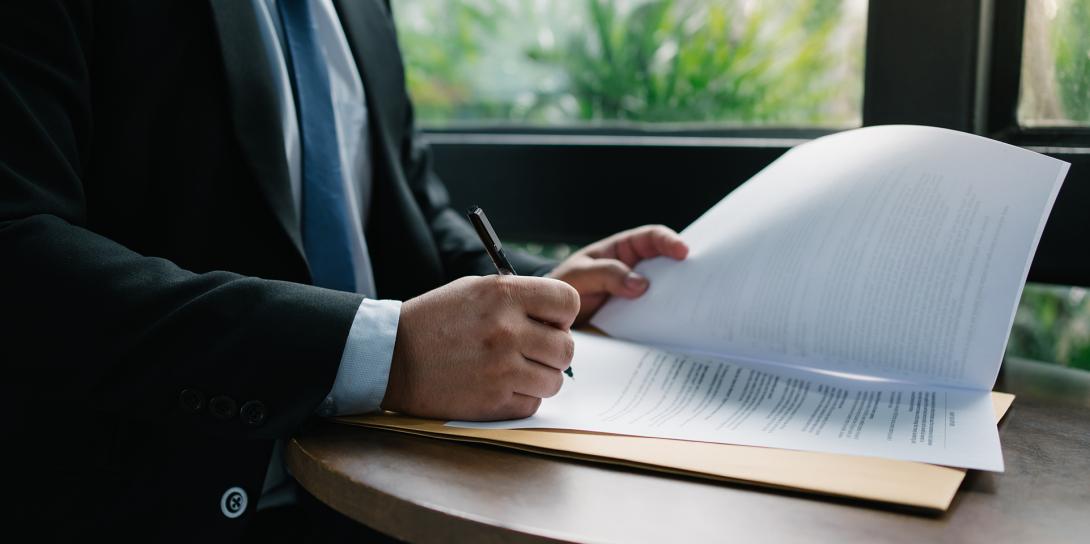 man writing on papers